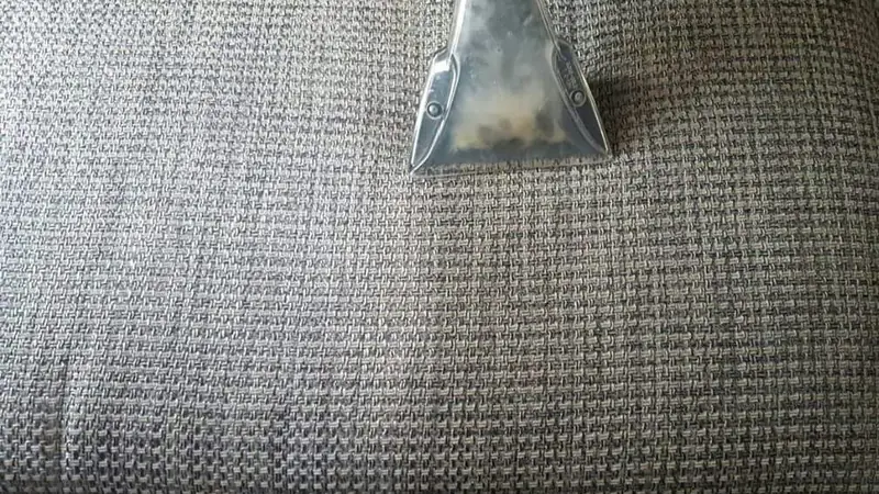 Polsterdüse eines Sprühextraktionsgeräts auf einem Stoffbezug